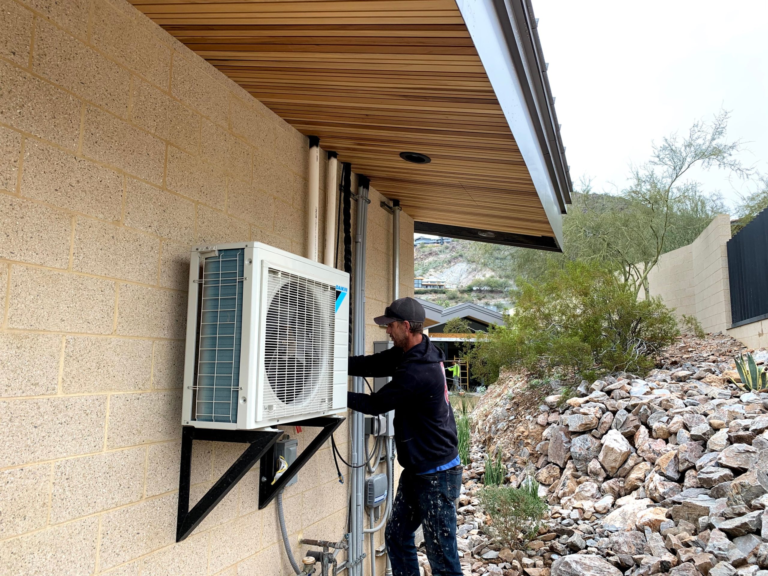 A professional HVAC technician working on an air conditioning unit, indicating when to call for professional help.